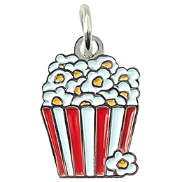 A red and white popcorn bucket overflowing with popcorn has been turned into a decorative metal charm.