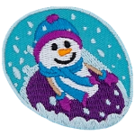 A smiling snowperson in mitts and a toque tubes down a hill in a purple tube.