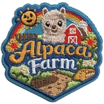 The words Alpaca Farm surrounded by a red barn, dirt path and a smiling sun.