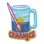 A glass painted with a sunset above the words Ceramics.