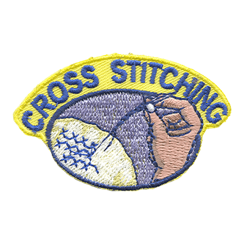 A hand holds a sewing needle with blue thread attached to a white cloth with blue Xs on it. The words Cross Stitching are above.