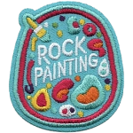 A rock with the words Rock Painting on it and various colourful shapes.