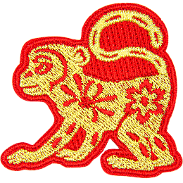 A gold monkey with a red outline and floral details on its body.