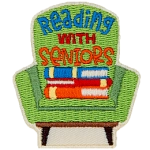 A green chair with a stack of books on it. The text reads Reading With Seniors. 