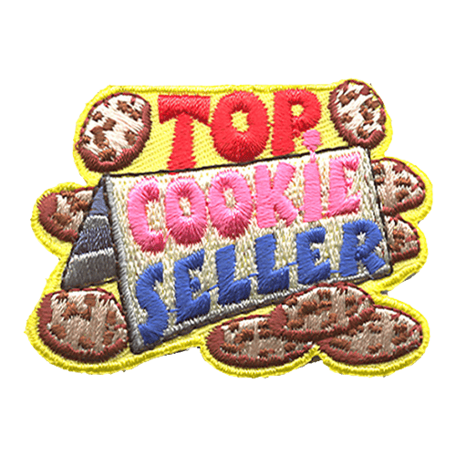 Top Cookie Seller is written above and on the paper. Cookies lay scattered around the sign.