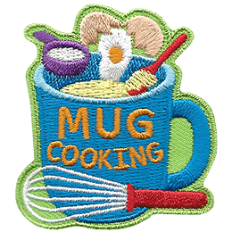 Flour, egg, and butter are being placed in a mug that has the words Mug Cooking on the side.