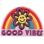 A smiling flower in front of a rainbow that reads Good Vibes.