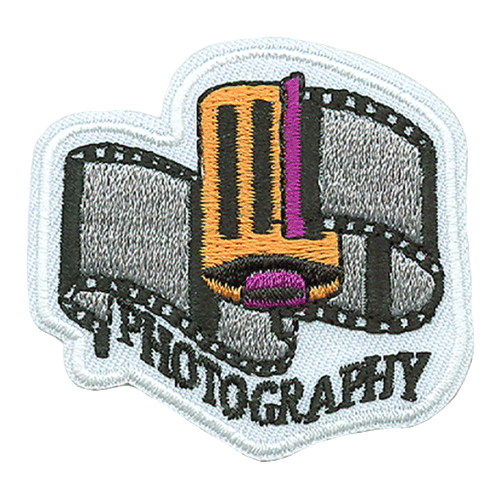 A partially unrolled piece of film, with the word Photography embroidered underneath. 