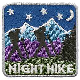 Two hikers walk on a grassy hill with mountains, stars, and a crescent moon in the background. Night Hike is stitched below. 