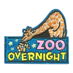 A giraffe leaning over a sign with the words Zoo Overnight on it.