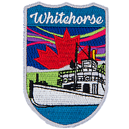 Whitehorse is stitched above a white river boat. There is a red maple leaf in the sky with the northern lights.