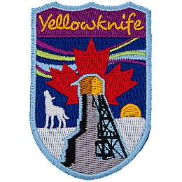 The name Yellowknife is above the northern lights and a howling wolf. A red maple leaf is in the middle of the sky.