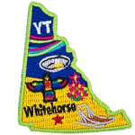 This patch is in the shape of the Canadian territory of Yukon, with the following symbols; the aurora borealis, gold panning, a totem pole, a dog sled, and Whitehorse.