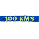 The number 100 KMS is stitched in yellow on a dark blue background.
