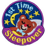 A teddy bear sleeps under a starry night sky. 1st Time Sleepover is stitched in a circle around them.