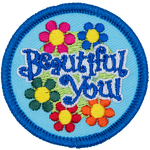 The words Beautiful You are in a patch of flowers.