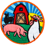 A pig and rooster are in front of a red barn. The silhouette of a cow is next to it. The sun is rising in the background.