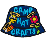 A blue camp hat has little crafts pinned to it. The text Camp Hat Crafts is embroidered on the side.