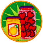 A jar of marmalade next to a jar of cherries.
