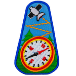 A satellite is above a compass in front of a forest of trees.