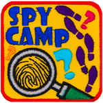 A magnifying glass magnifies a fingerprint. The words Spy Camp are above it, and the right side has shoe prints.
