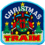 The front of a train is decorated with a wreath and lights. The words Christmas Train are above and below. Two trees frame either side.
