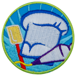 A chef's hat, a spatula and a pipping bag are inside a circular patch.