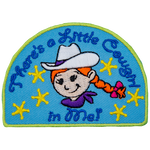 The words There's A Little Cowgirl In Me are above and below a little girl with braided red hair and a white cowboy hat.