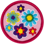 Blue, pink, purple and yellow flowers are clustered together on a pink background.