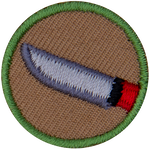 This one-inch circle badge depicts a sharp-bladed knife with a red handle.