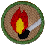 This round one inch badge depicts a lit match.