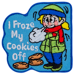 A young girl is bundled up in a hat, scarf, jacket, and thick pants as she stands shivering in the cold. Three cookies lie under the text I Froze My Cookies Off.