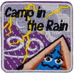 A tent with a scared expression on it watches a lightning storm. The words Camp In The Rain are above it.