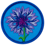 A purple cornflower is in the centre of a blue, circular patch.