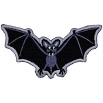 A bat with fangs stares at the viewer. Its wings are outstretched.