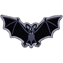 A bat with fangs stares at the viewer. Its wings are outstretched.