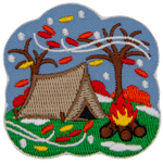 A single tent sitting next to a campfire is framed by two bare trees. Snow and leaves are blown across the patch.