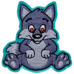 An adorable wolf pup sits on its bottom and smiles at the viewer with big brown eyes.