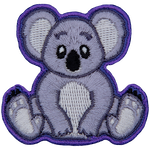 A cute koala bear is sitting down and staring straight ahead.