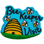 A bee hive sits on a grassy field. Four bees buzz around the words Bee Keeper Visit.