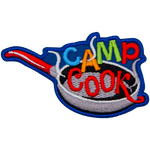The words Camp Cook are being fried in a frying pan.