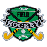 Two hockey sticks are crossed over each other with a ball on the shield-shaped field behind them. The words Field Hockey are stitched across the middle.