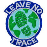 Earth with a boot print across the ocean. The words Leave No Trace are written around the outside.