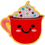 A red mug of cocoa is topped with whipped cream and sprinkles. The mug has dots for eyes and a big U-shaped smile.