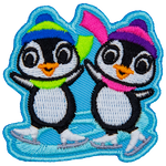 Two penguins skate on a swirl of ice. Both penguins wear winter hats and scarves.