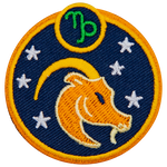This circular crest has the side profile of a goat surrounded by stars. The sign of Capricorn sits above his head.