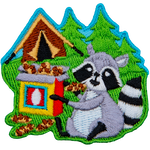 A raccoon happily munches on a box of chocolate chip cookies that it swiped from a tent.