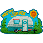 The words Happy Camper are in the sky above a camper on a sunny day.