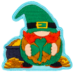 A gnome leprechaun holds a shamrock and stands in front of a pot of gold.