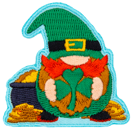 A gnome leprechaun holds a shamrock and stands in front of a pot of gold.